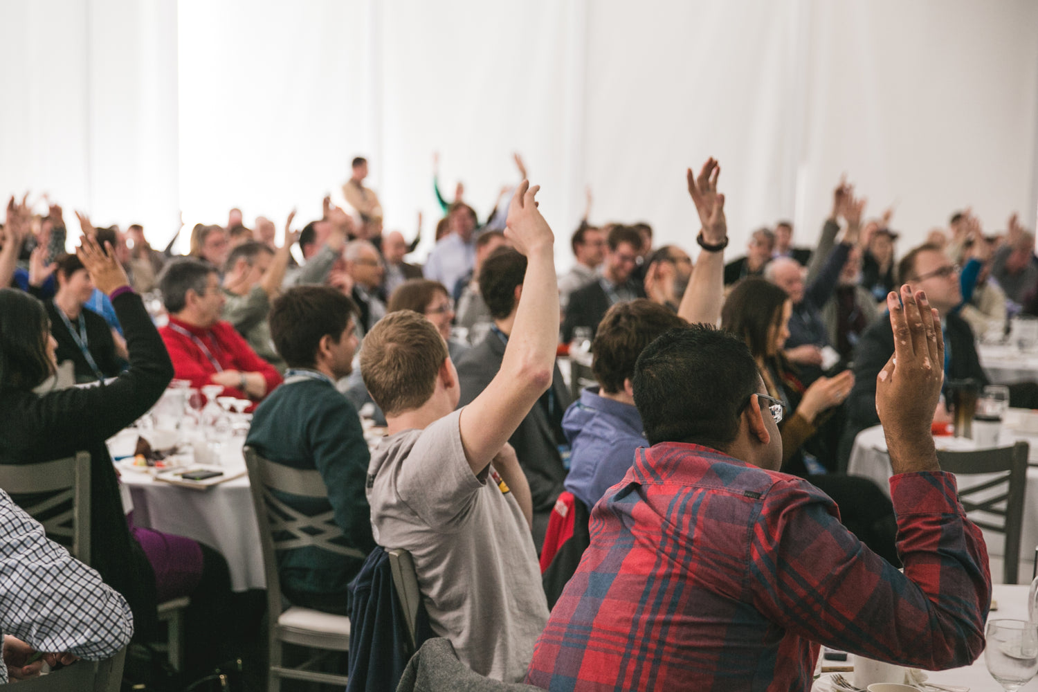 People with their hand raised at an event